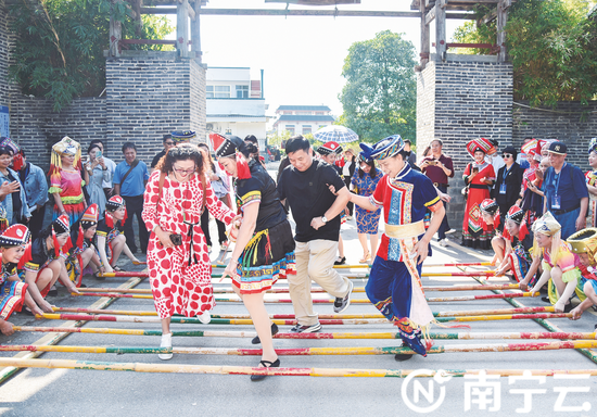 在上林县霞客桃源景区，诗人们跳起欢快的竹竿舞，体验南宁民俗风情。