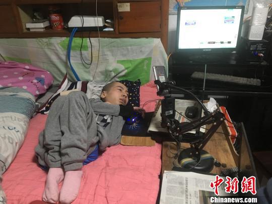 伏培建躺在床上通过网络和外界接触。 刘林 摄