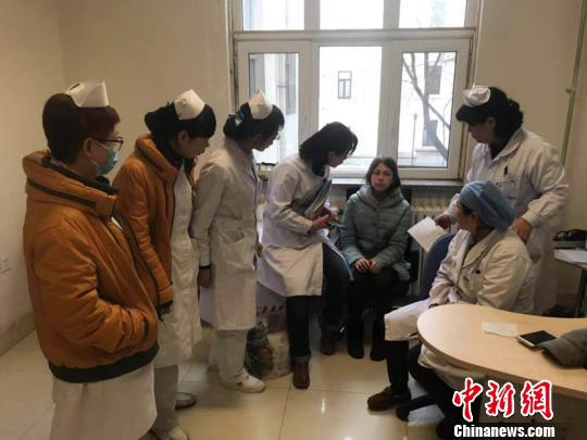 图为安娜和医护人员进行交流。(高军震摄)