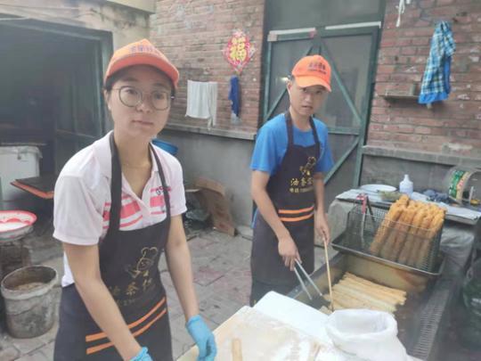 任晓猛、任文亚夫妻正在自家租住的小院里炸油条。