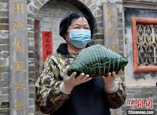 粱受轩刚包好用一只整鸡做馅的大粽子。 翟李强 摄