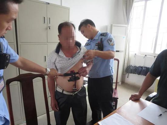 上图为监考民警在检查考生覃某身上作弊器材