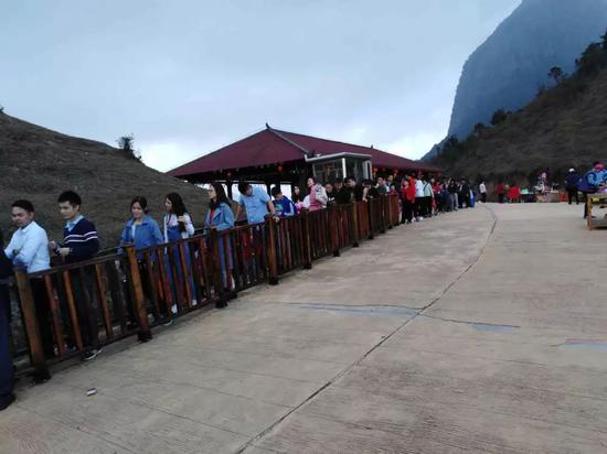 游客在天龙顶山地公园内排队乘车登山。