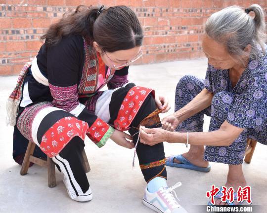 队员试穿瑶族嫁衣 罗咏春 摄