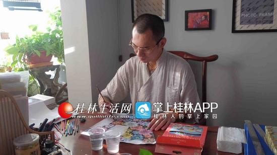 戴望在画一幅“百花不落地”的图案。