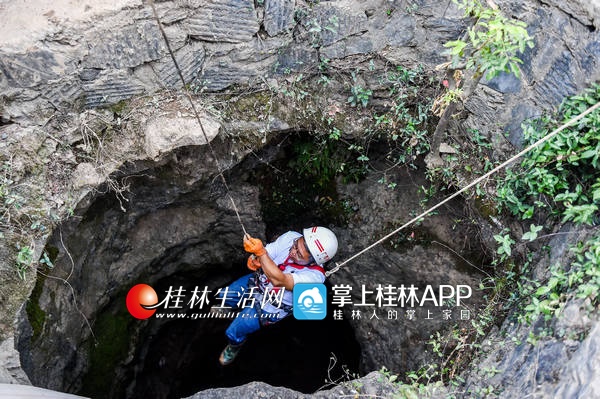 从南宁赶来的文物考古专家正在下井去查看骸骨。记者游拥军 实习生谢汶宏 摄