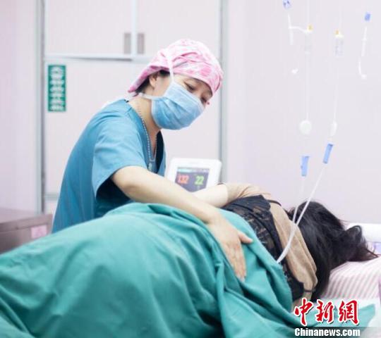 一轮阵痛过后,李丽又帮她擦汗喂水,并不断鼓励。 范丽芳 摄