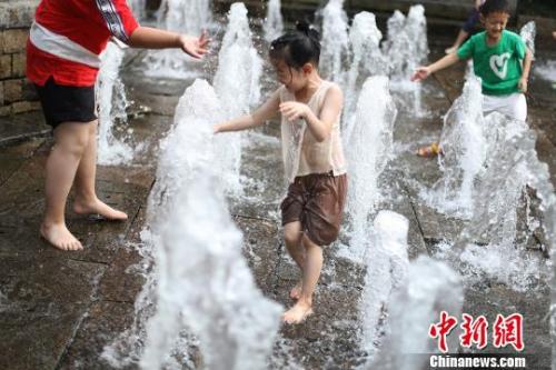 7月10日,南京迎来高温天气,孩子们在街头的喷泉处戏水觅清凉。泱波 摄