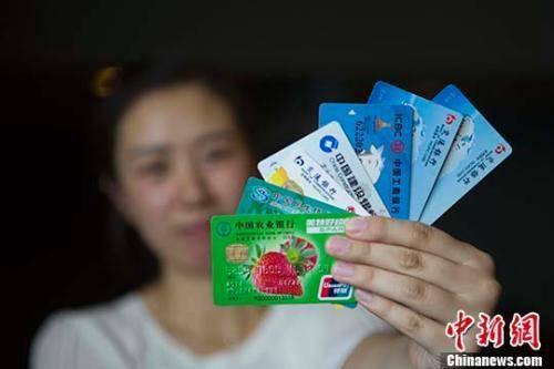 资料图:民众展示银行卡。 中新社记者 张云 摄