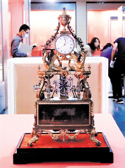“铜镀金嵌料花转水法跑人上顶瓶式规矩钟”十分精美