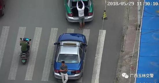 男子斑马线上违法停车,用身体遮挡号牌。