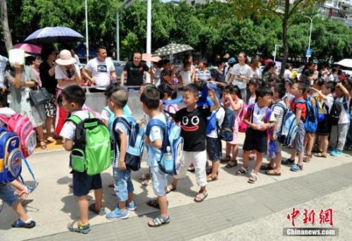 资料图:家长们在校外等候自己刚上小学一年级的小孩。张斌 摄
