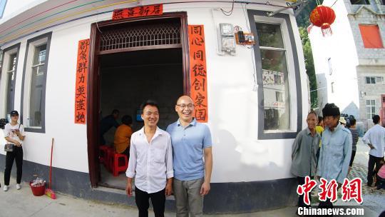 图为帮扶干部和搬迁户合影。 米儒聪 摄