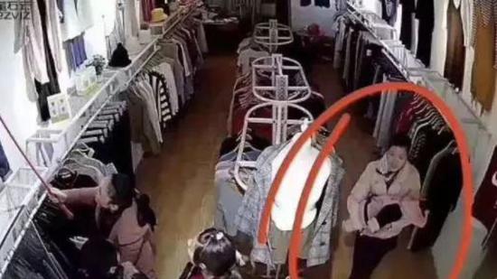 女婴在服装店内被抱走时,其母正在一旁招徕顾客。受访者供图