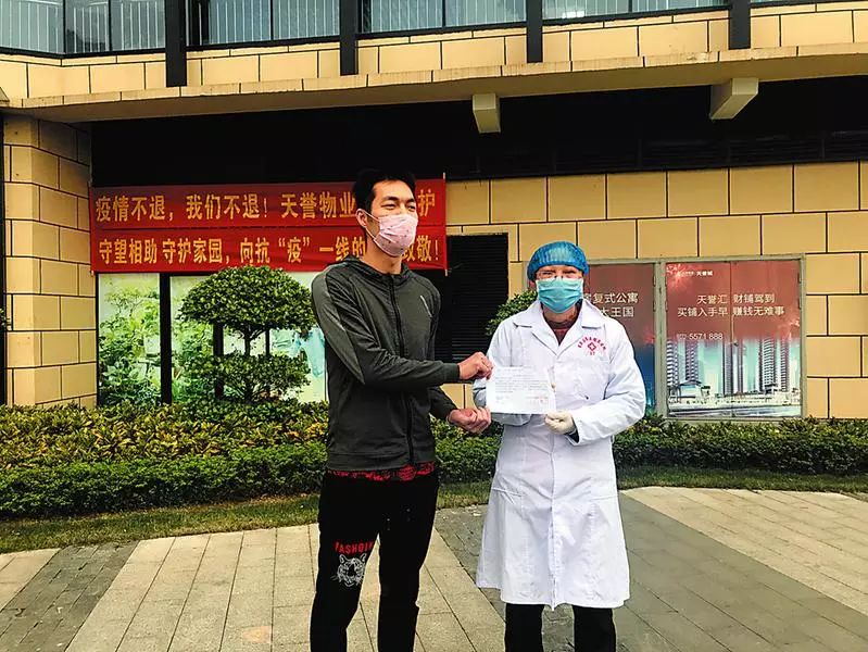 △医护人员向业主代表发放结束隔离(留观)告知书。何璨汐 摄