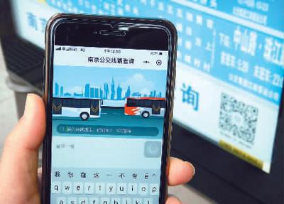 南京新街口公交站站牌上新发布的“南京公交线路查询”微信小程序吸引着乘客。