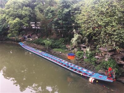 昨日,距翻船事故发生地百余米外,一艘龙舟停在桃花江边。