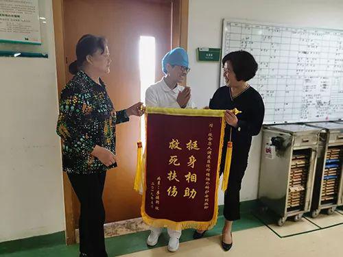 李老师家属为好护士刘淑卿(中间)送上锦旗。姚毅 摄