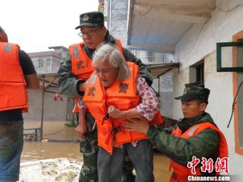 图为武警官兵转移受灾民众。 杨陈 摄