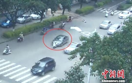 图为肇事车辆顶着电动车继续前行。监控截图