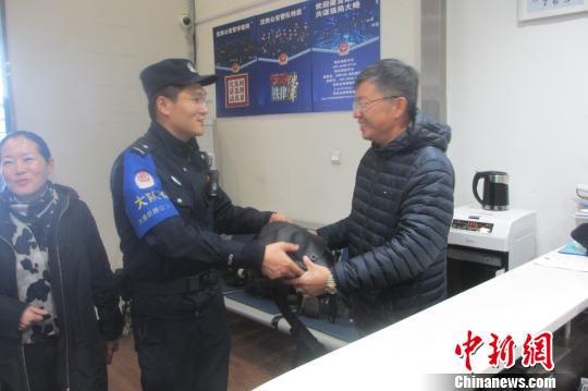 图为民警将遗失物品归还失主。 张海邦 摄
