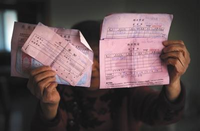 2月24日,房山某小区,85岁的杨慧(化名)拿着几张买收藏品时的收据和购买凭证。