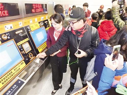 地铁工作人员向市民介绍无人购票机的使用方法记者 赖有光 摄