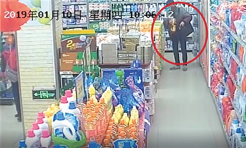 ◀班某在超市把花生油塞进公文包时被监控拍到 (视频截图)