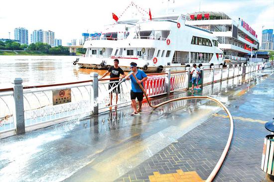 工作人员清洗曾被洪水淹没的亲水平台 本报记者宋延康摄