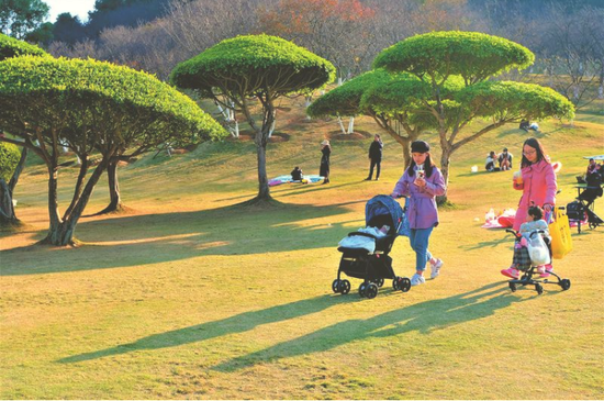 天气回暖,市民带孩子在公园晒太阳 本报记者宋延康摄