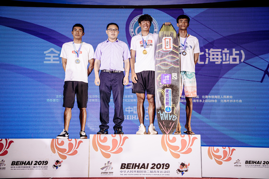 *北海市旅游文体局局长鲁性东为获得全国锦标赛双向板男子专业组前三名的运动员颁奖