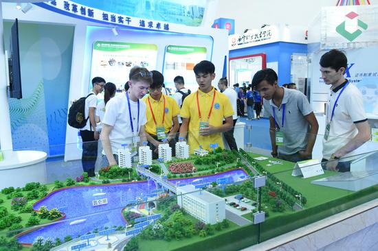 外国友人认真观看学院展品路桥教学工场 ，并咨询国际学生招生事宜