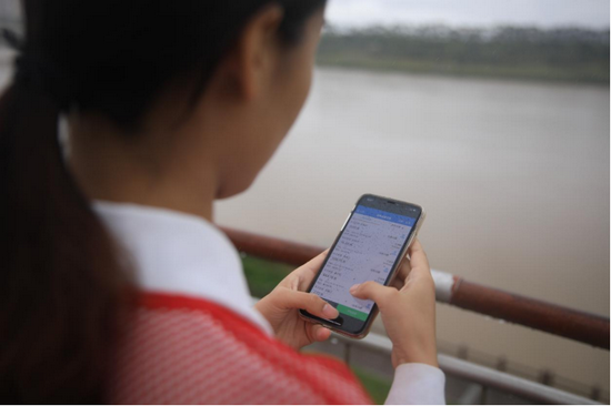 工作人员正在使用河长制云平台手机端查看实时水质数据