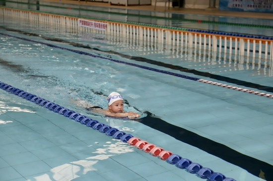 参加蹼泳比赛的小朋友在泳道上和自己比赛