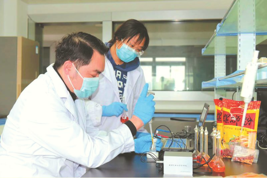研究人员使用辣度快速分析仪对螺蛳粉调味包辣度进行测试实验 (广西农科院供图)