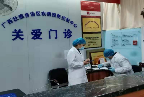 医护人员正在电话联系艾滋病患者并在手机上互相核对患者发来的信息地址