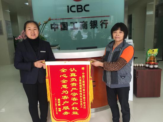 图为客户陆阿姨向工行南宁市佛子岭支行赠送锦旗感谢该行帮助其堵截电信诈骗