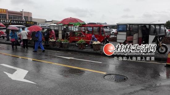 人行道被揽客三轮车与小摊贩占据,无人管理,乘客只能走在机动车道上。