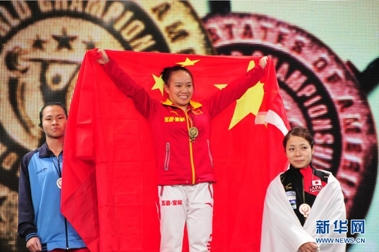 11月21日,中国选手蒋惠花(中)在颁奖仪式上。当日,在美国休斯敦举行的2015年世界举重锦标赛女子48公斤级比赛中,中国选手蒋惠花以198公斤的总成绩夺冠。 新华社记者张永兴摄