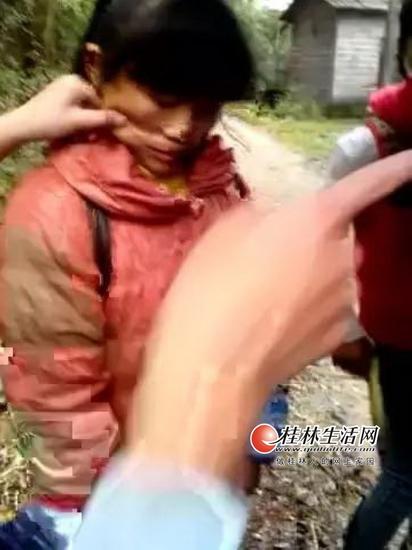 灌阳打人事件中,有人捏被打女孩的脸。(视频截图)