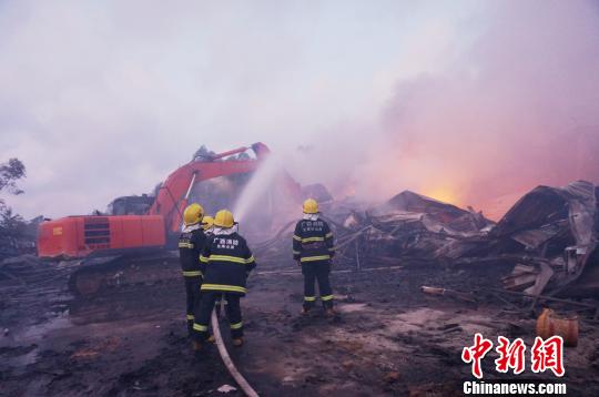 图为救援人员在射水防止复燃。 仇斌 摄