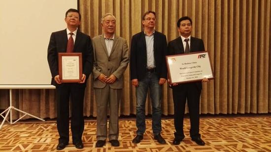 贺州市人民政府市长李宏庆(左一)、贺州市市委常委,宣传部部长,副市长朱东(右一),代表贺州接受国际人口老龄化长寿化指导委员会副主席邹平和国际地理联合会健康与环境委员会主席汤马斯。克拉福颁发的“世界长寿市”证书和牌匾。