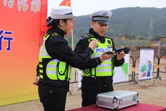 交警向农民工展示网枪装备 韦宛辰/摄