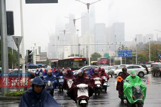 11日南宁市民冒雨出行