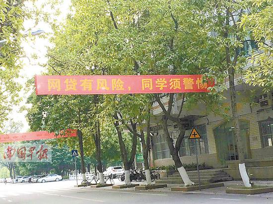 大学校园内挂着“网贷有风险，同学须警惕”的横幅。