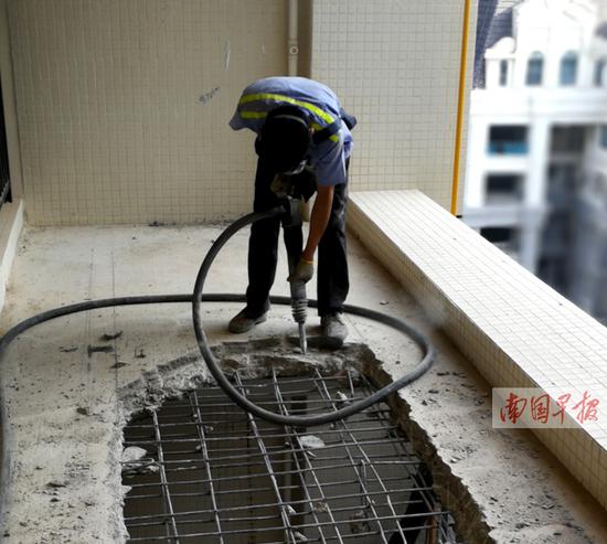 施工人员正在拆除违规建设的“阳台”。 记者 李俭芹摄b