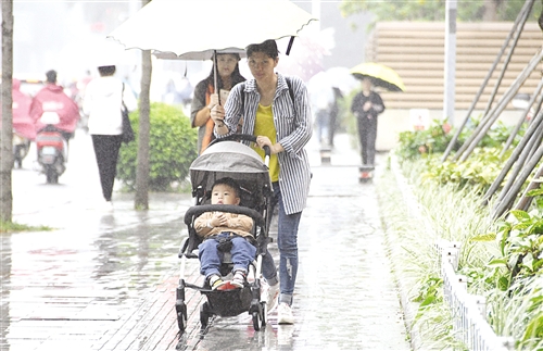 南宁这几天降雨降温,人们穿上外套打起伞