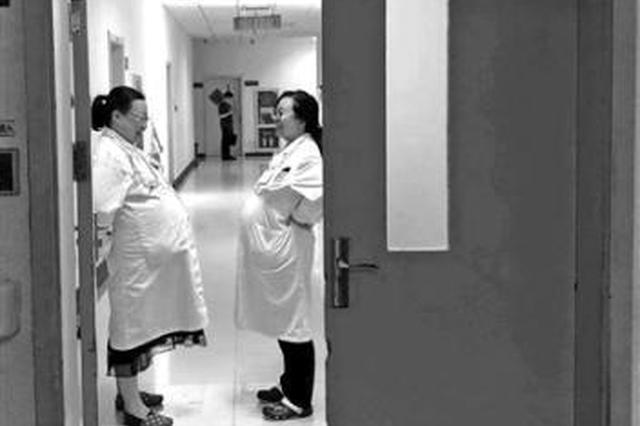 孕妇医生临产仍坚守岗位 相视一笑成