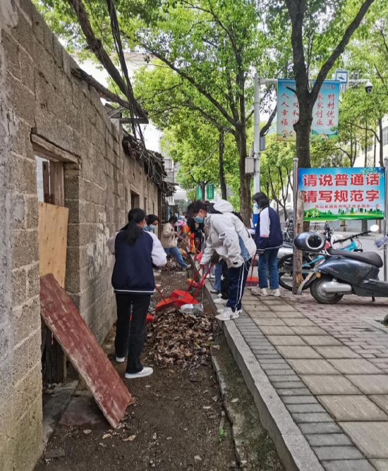 图1：3月31日上午，凤山县民族中学师生在教育路中段清理垃圾