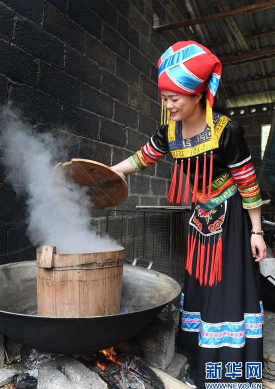 3月25日,在广西上林县巷贤镇,一名壮族女子在蒸制五色糯米饭。 新华社记者 陆波岸 摄